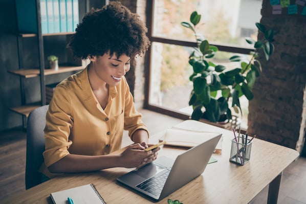 Woman using laptop and smartphone